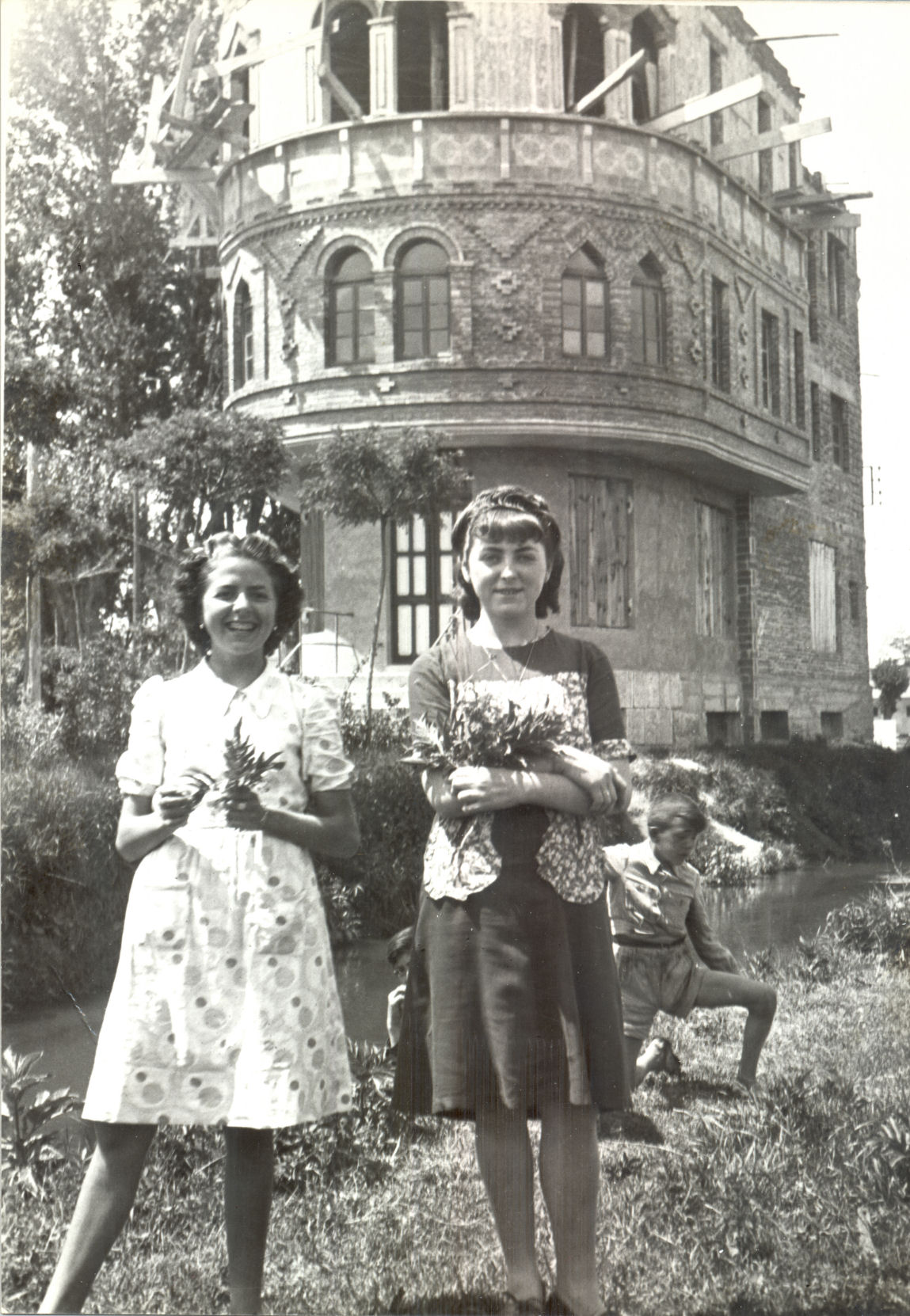 Dos chicas de pie y un joven junto al riachuelo frente a la Casa del Barco en los años 30